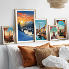 Framed Whistler wall art ski print showcasing a sunset over the mountains, complemented by other city prints on a stylish bed setup.