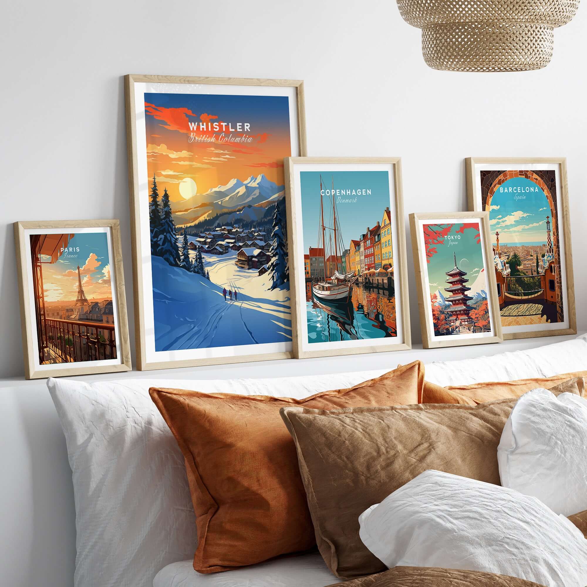Framed Whistler wall art ski print showcasing a sunset over the mountains, complemented by other city prints on a stylish bed setup.