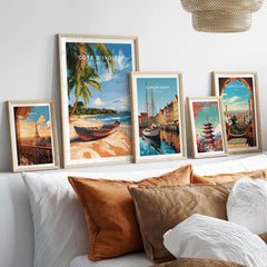 Côte d'Ivoire Beach Wall Art displayed among other travel prints on a stylish bed with cushions.