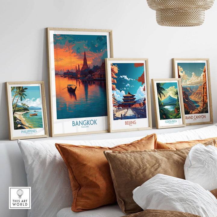 Contemporary art display featuring travel posters of Bangkok, Beijing, Costa Rica, and the Philippines on a cozy sofa.