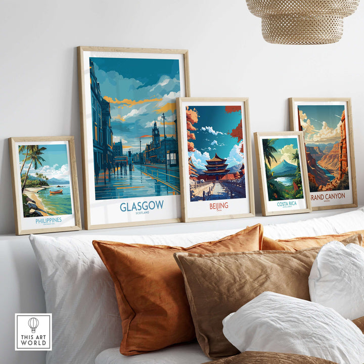 Framed travel posters of Glasgow, Beijing, Costa Rica, and the Philippines displayed on a couch in a stylish living room.