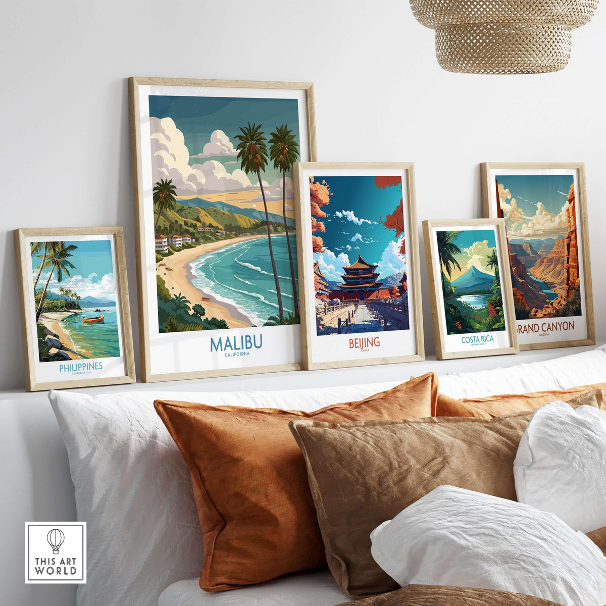 Malibu California Poster - Beach Print displayed among travel posters on a cozy sofa setting.