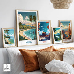 Malibu California Poster - Beach Print displayed among travel posters on a cozy sofa setting.