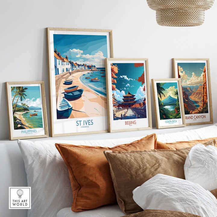 Colorful framed travel posters on a wall, showcasing St Ives, Beijing, Costa Rica, Philippines, and the Grand Canyon.