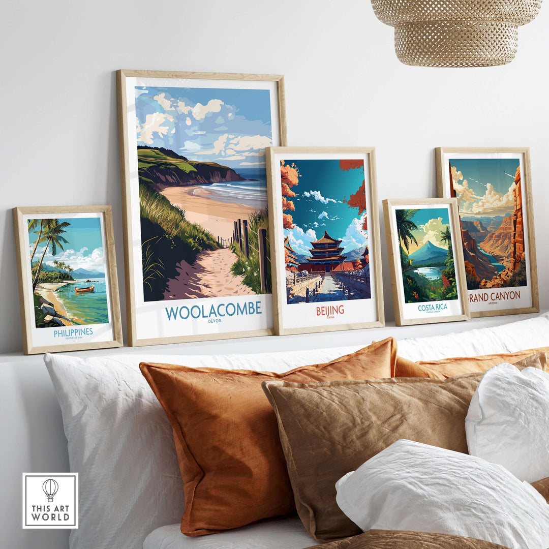 Framed posters of Woolacombe, Philippines, Beijing, Costa Rica, and Grand Canyon displayed on a modern shelf.