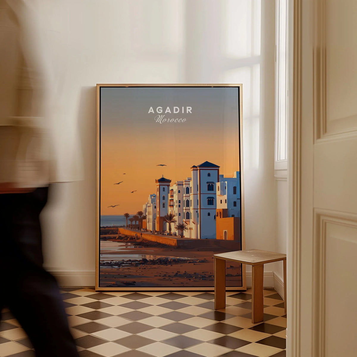 Agadir Travel Poster – Morocco Beach Print as a framed canvas leaning in a hallway with a chequered tiled floor