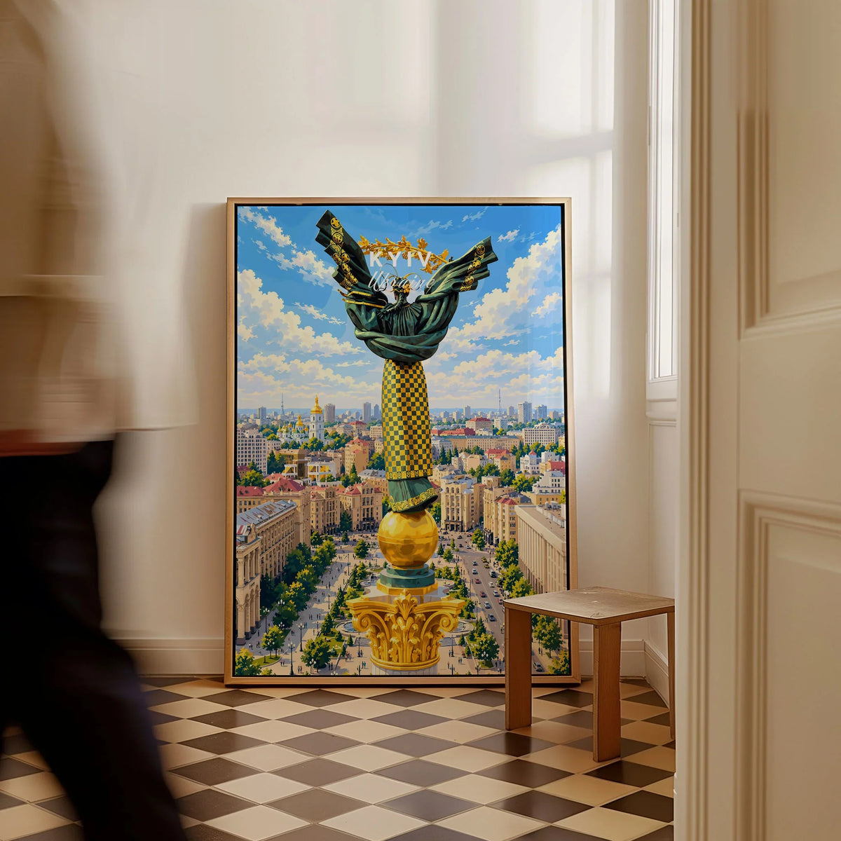 Kyiv Ukraine Independence Monument Travel Poster — the Independence Monument rising above Maidan Nezalezhnosti and the Kyiv skyline, shown as framed canvas on floor man walking past