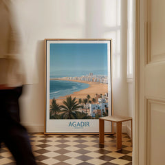 Agadir Morocco Print – Panoramic Beach and Palm Tree Wall Decor as a framed canvas leaning in a hallway with a chequered tiled floor