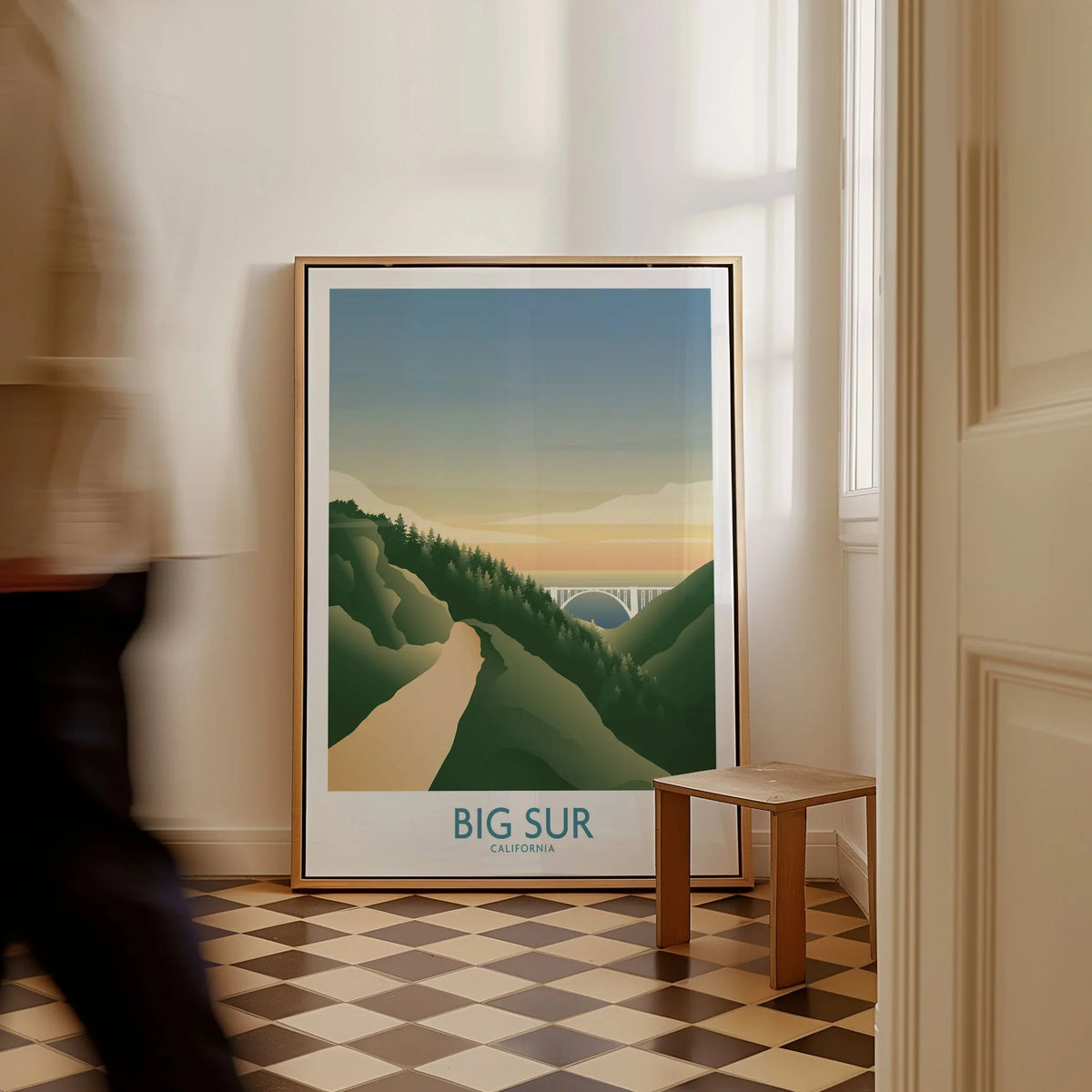 Big Sur California Art Print as a framed canvas leaning in a hallway with a chequered tiled floor