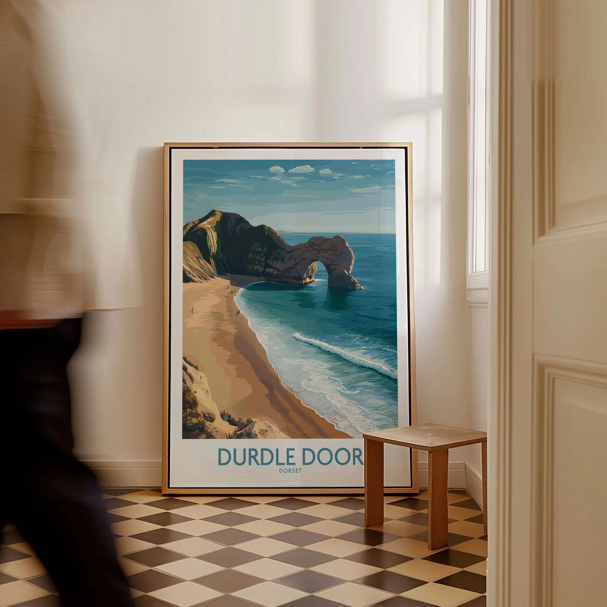 Durdle Door Art Print Dorset Wall Art as a framed canvas leaning in a hallway with a chequered tiled floor
