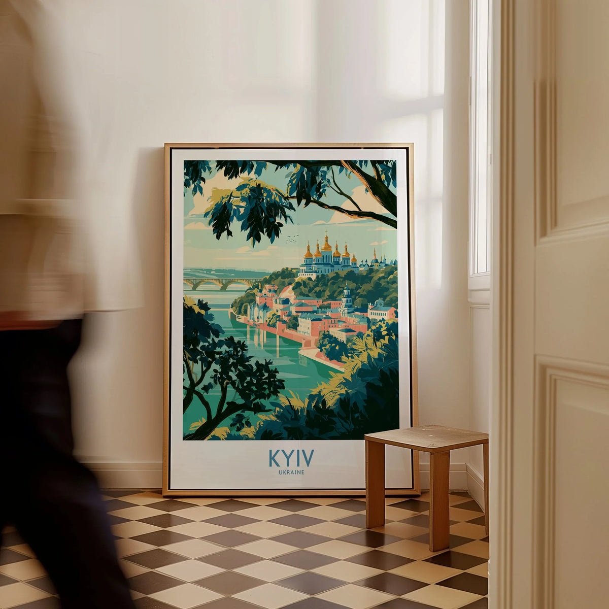 Kyiv Ukraine Dnipro River Wall Art — golden domes on a wooded bluff above the Dnipro river, shown as framed canvas on floor man walking past