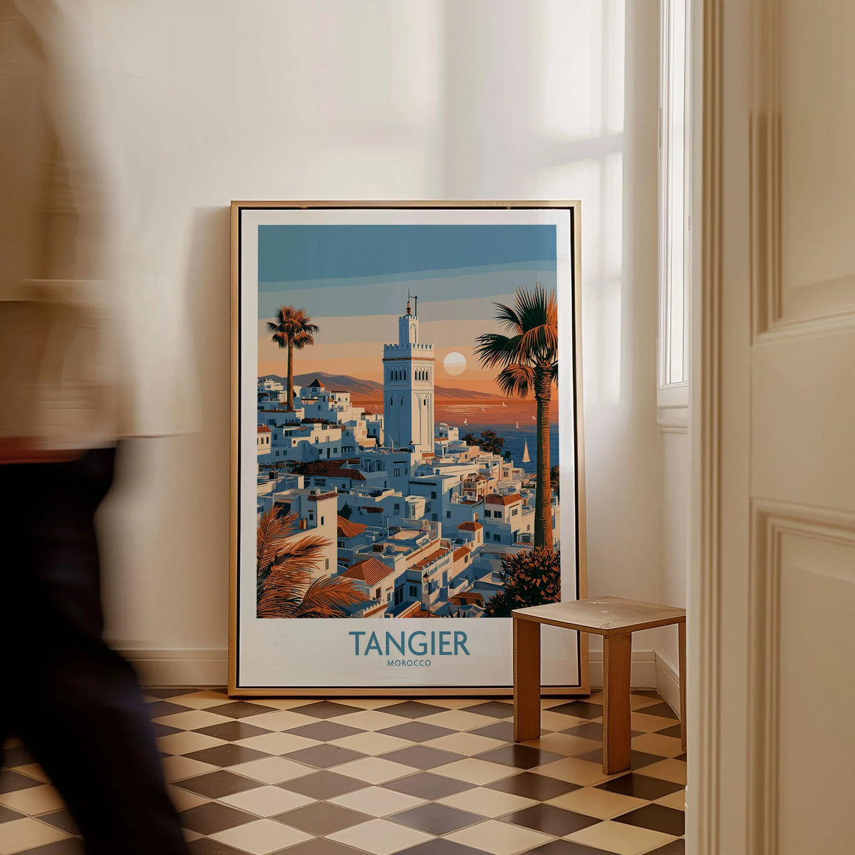 Tangier Morocco Sailboats and Rooftops Wall Art — Tangier medina rooftops and a minaret above a bay dotted with sails, shown as framed canvas on floor man walking past