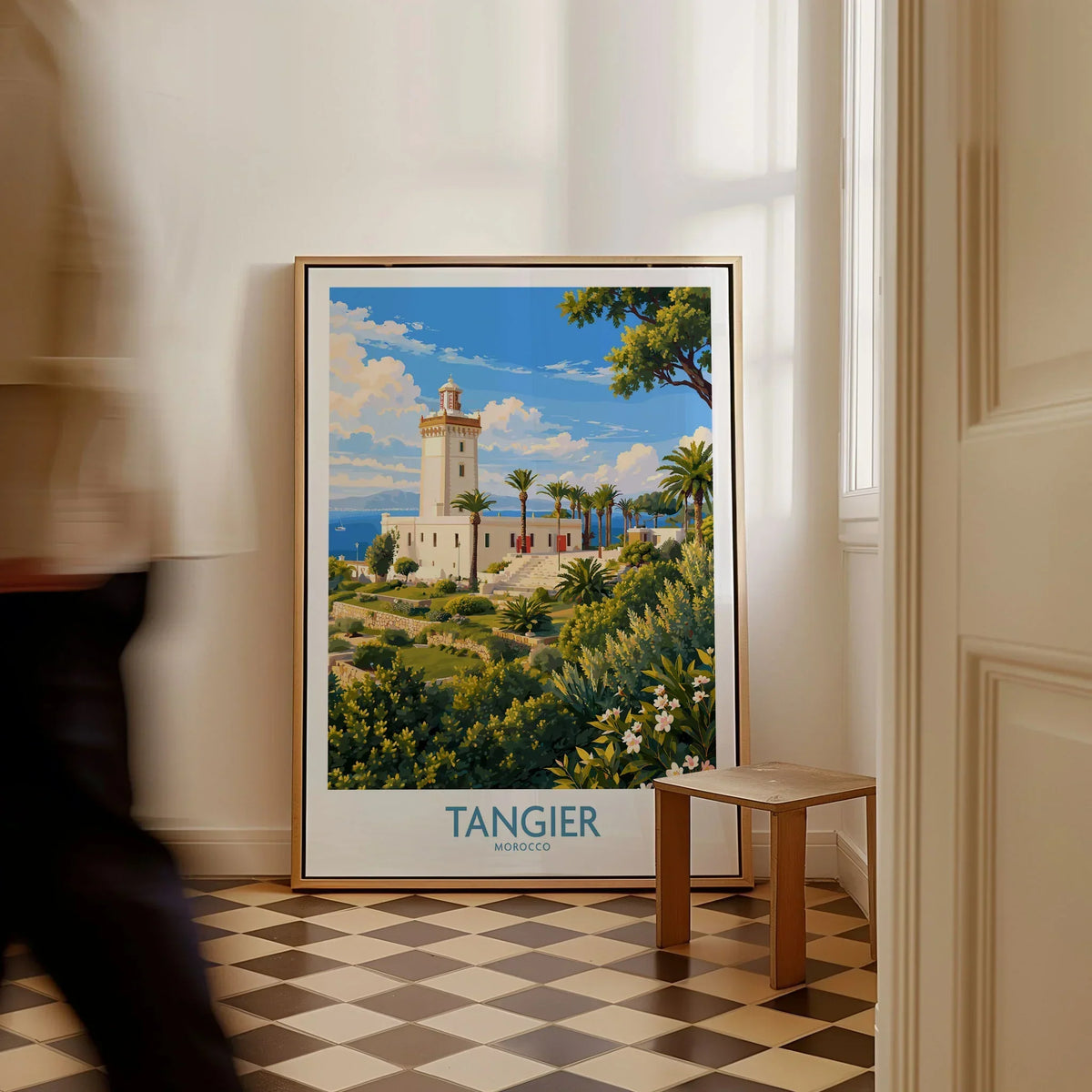 Tangier Morocco Lighthouse Gardens Wall Art — the Cap Spartel lighthouse above palm gardens and the blue strait, shown as framed canvas on floor man walking past