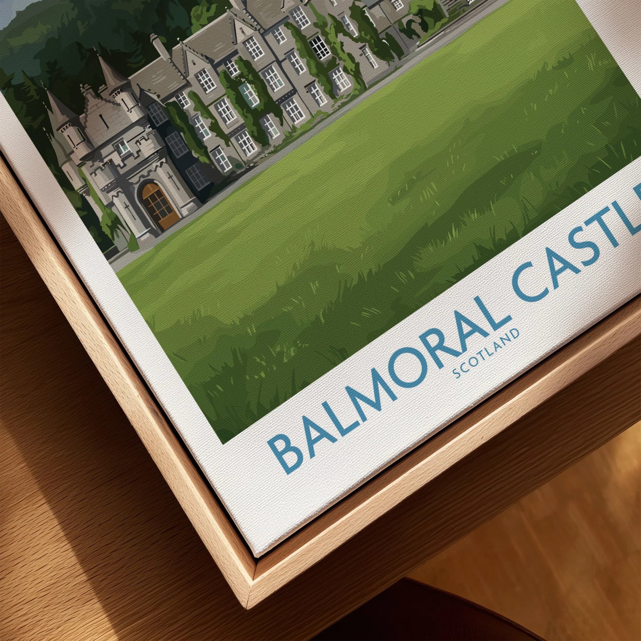 Close-up of a framed Balmoral Castle Scotland travel poster with natural wood floating frame.