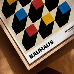 Bauhaus Exhibition Prints - Isometric Cubes Art Print Red Yellow Blue Design showcased on a wooden surface.