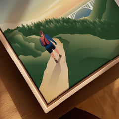 Closeup of framed canvas art showing a hiker on a forest trail with a bridge at sunset.