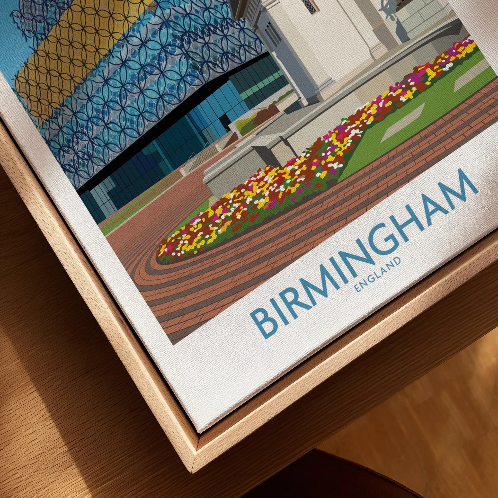Close-up of Birmingham city wall art print in natural wood floating frame, featuring colorful flowers, modern architecture, and 'Birmingham England' text.