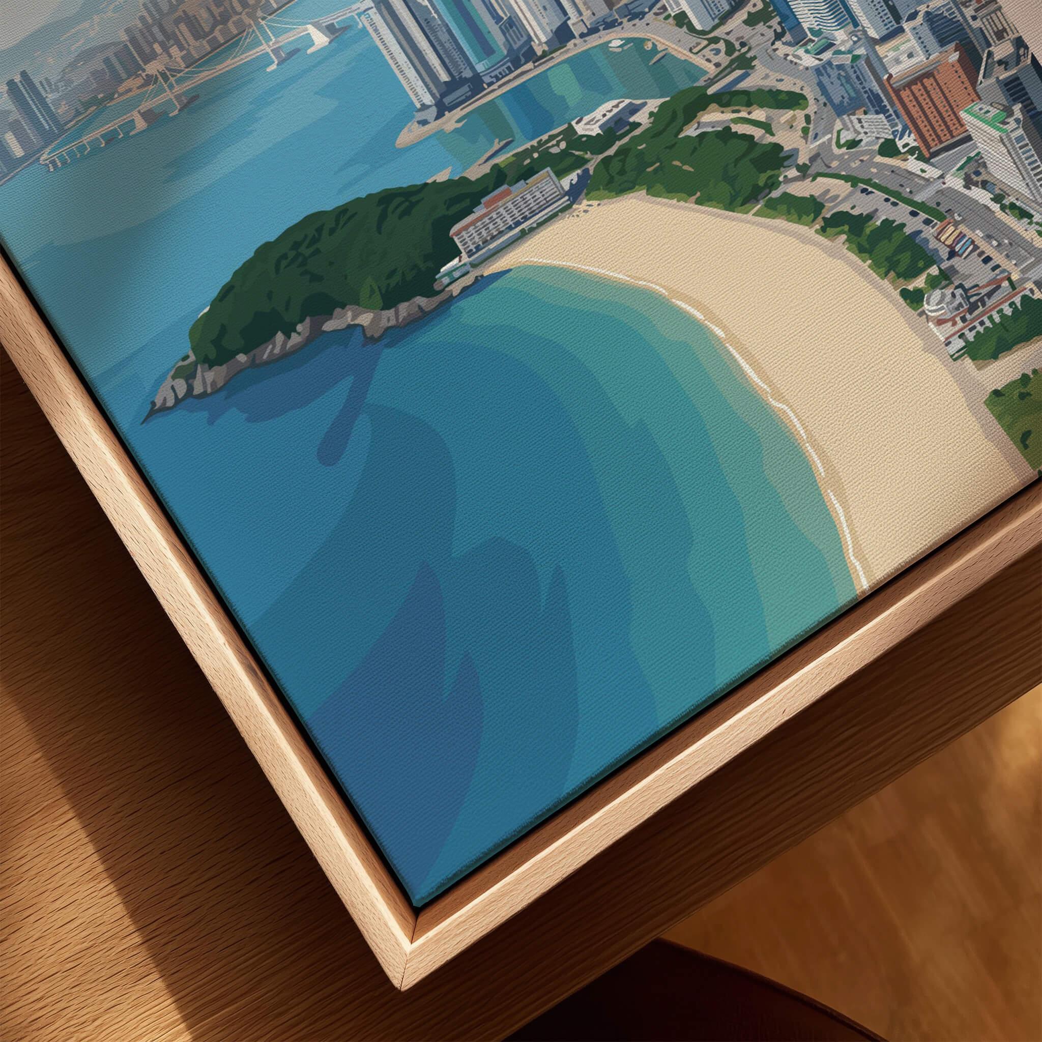 Close-up of framed city and beach canvas wall art in natural wood floating frame