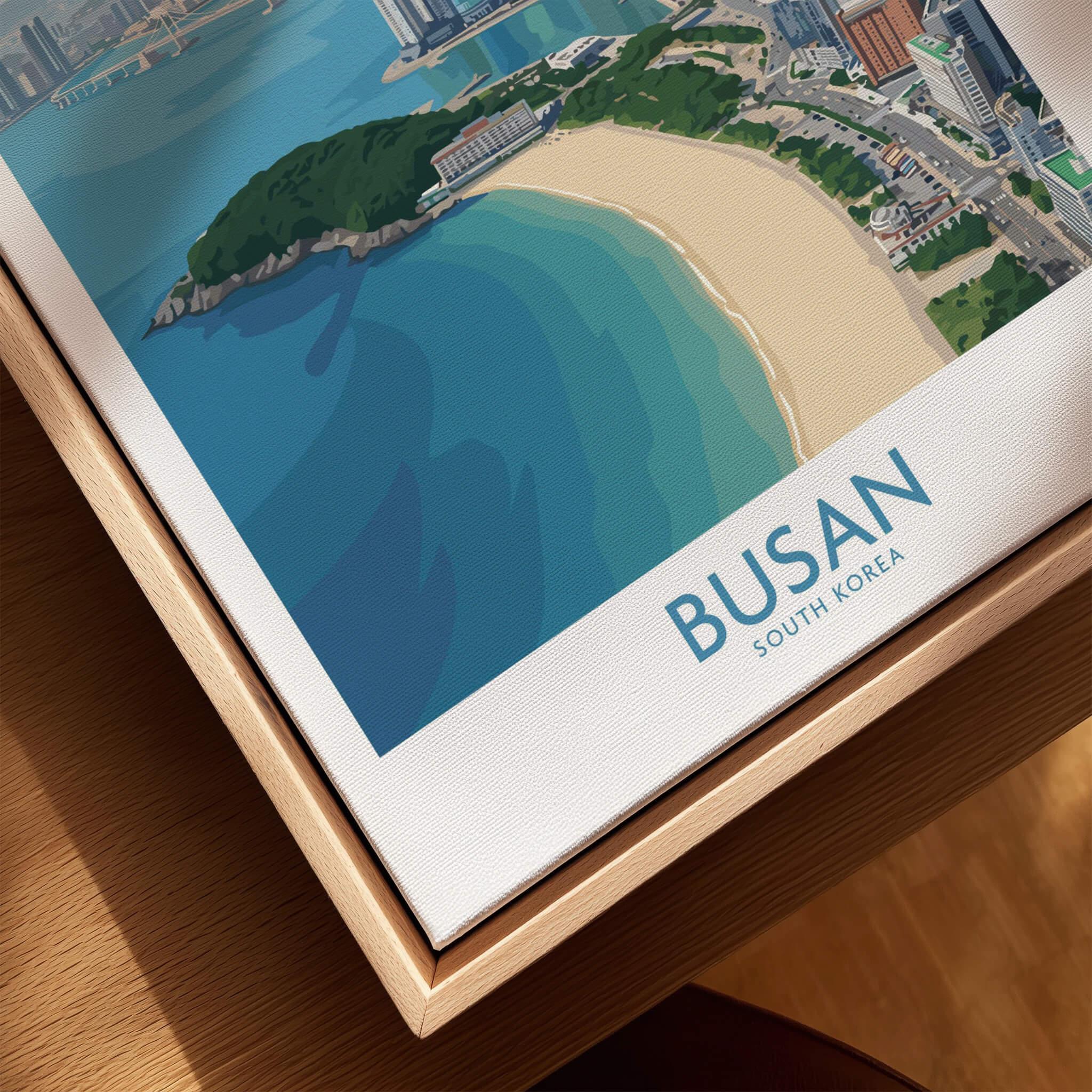 Closeup of framed canvas travel poster featuring Busan South Korea beach and cityscape.
