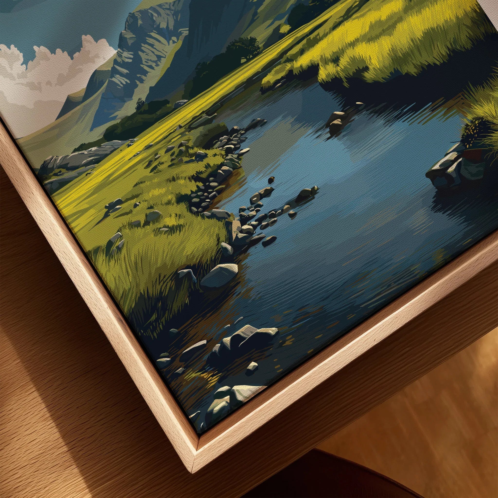 Closeup of framed canvas wall art featuring a mountain landscape with lake and grassy meadow.