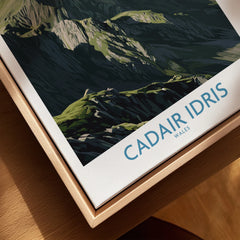 Closeup of Cadair Idris Wales travel poster in natural wood floating frame
