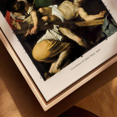Caravaggio Art Print - Crucifixion of Saint Peter 1601 displayed on a wooden frame.