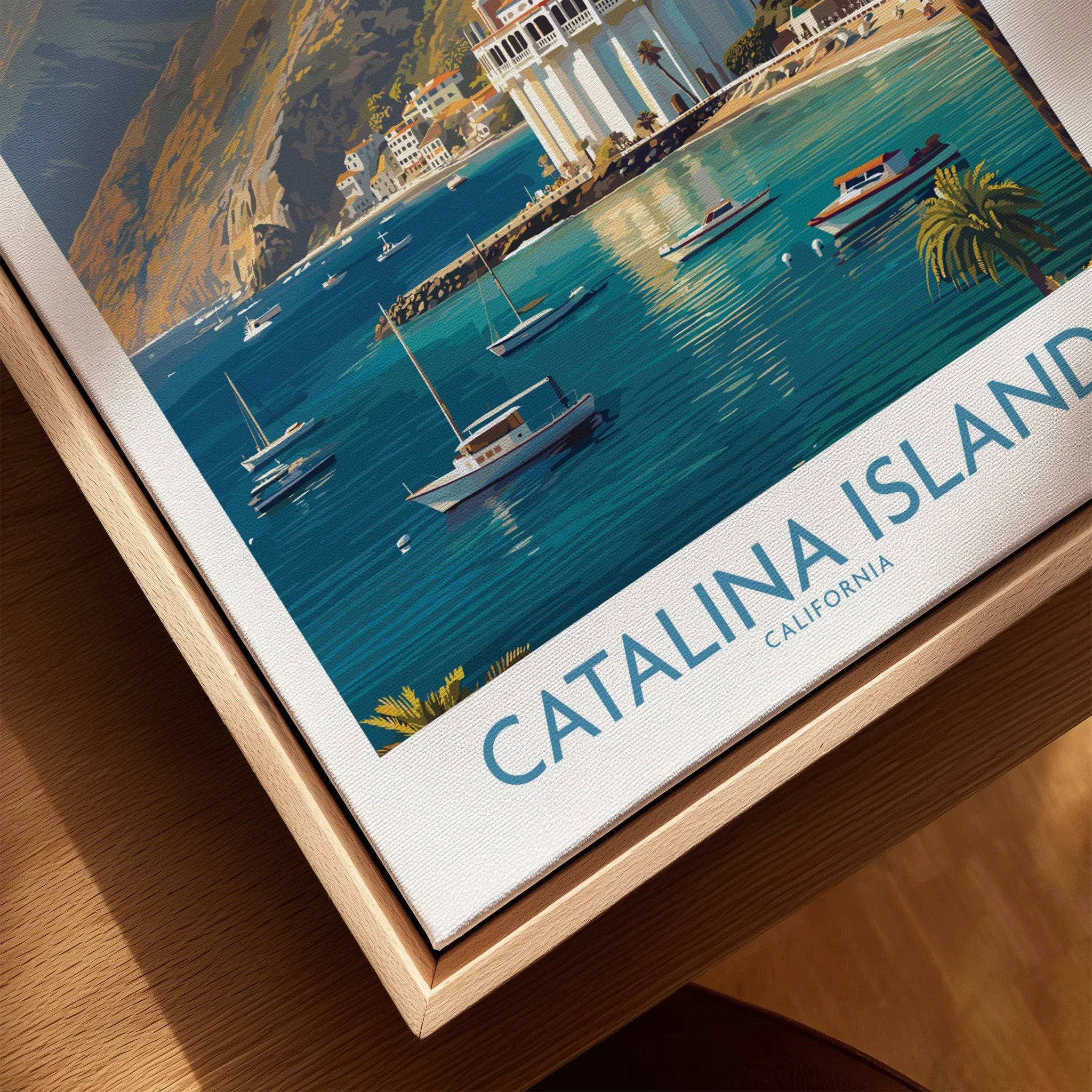 Closeup of Catalina Island travel poster print in natural wood floating frame with boats and water.