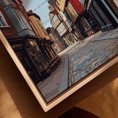 Close-up of framed city street art print with natural wood floating frame