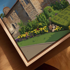 Closeup of framed canvas wall art with natural wood floating frame, depicting a historic stone building and colorful garden.