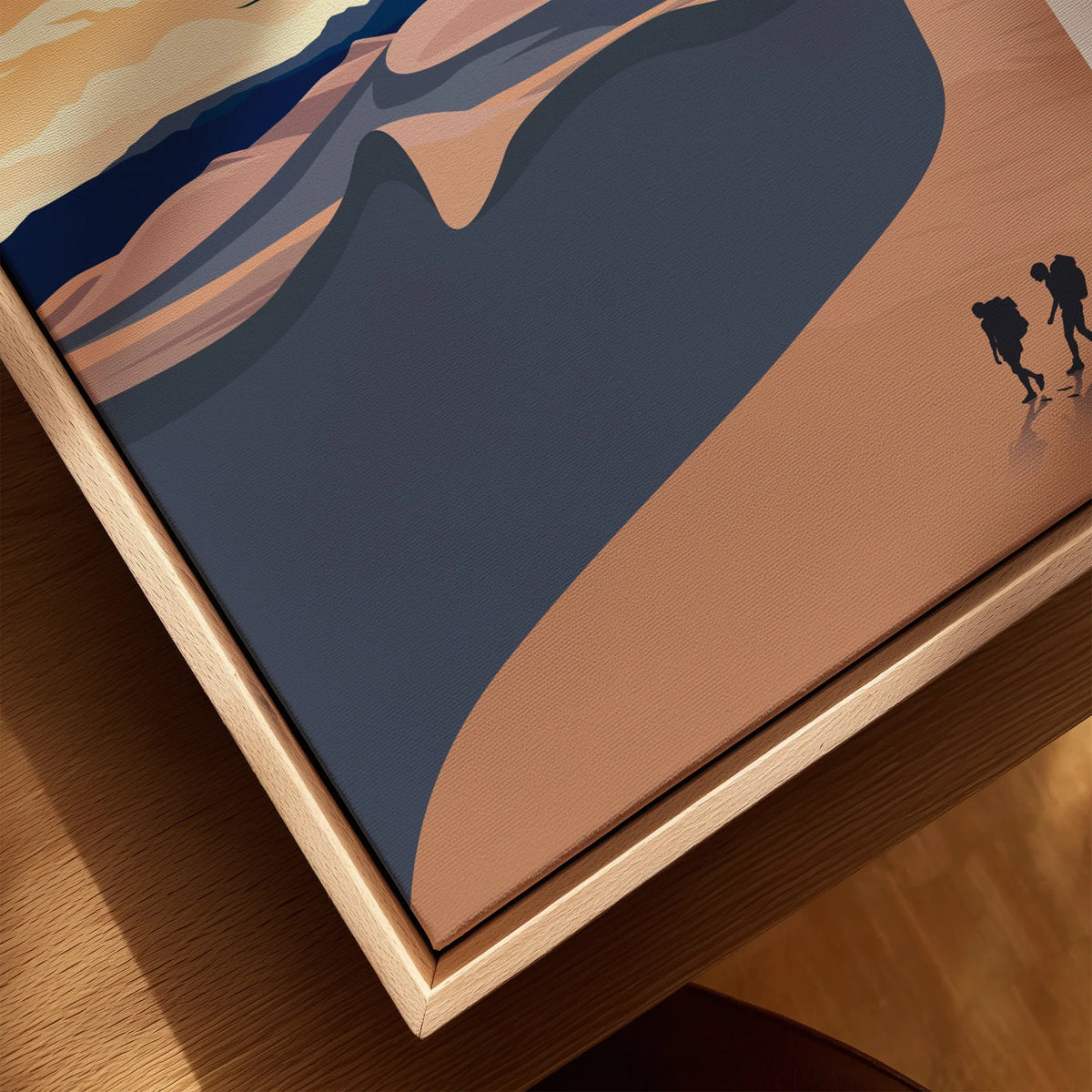 Close-up of framed canvas wall art with desert landscape and hikers, natural wood floating frame