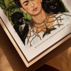 Frida Kahlo Self Portrait with Thorn Necklace and Hummingbird Print in a wooden frame, showcasing symbolic elements.