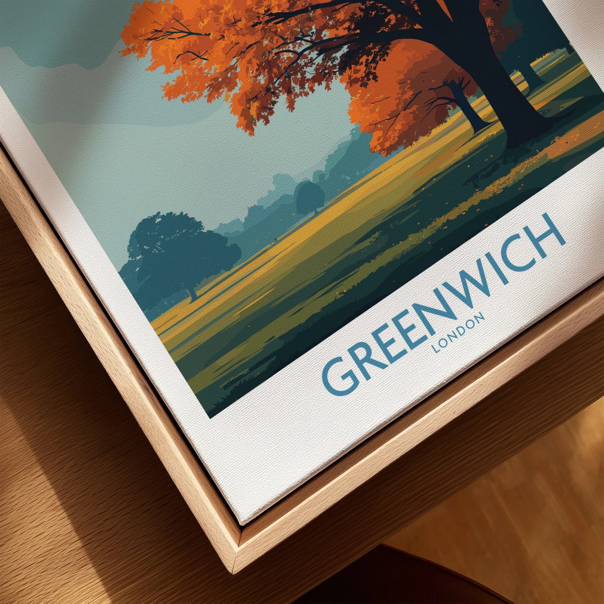 Closeup of framed Greenwich London travel poster with autumn trees and natural wood float frame