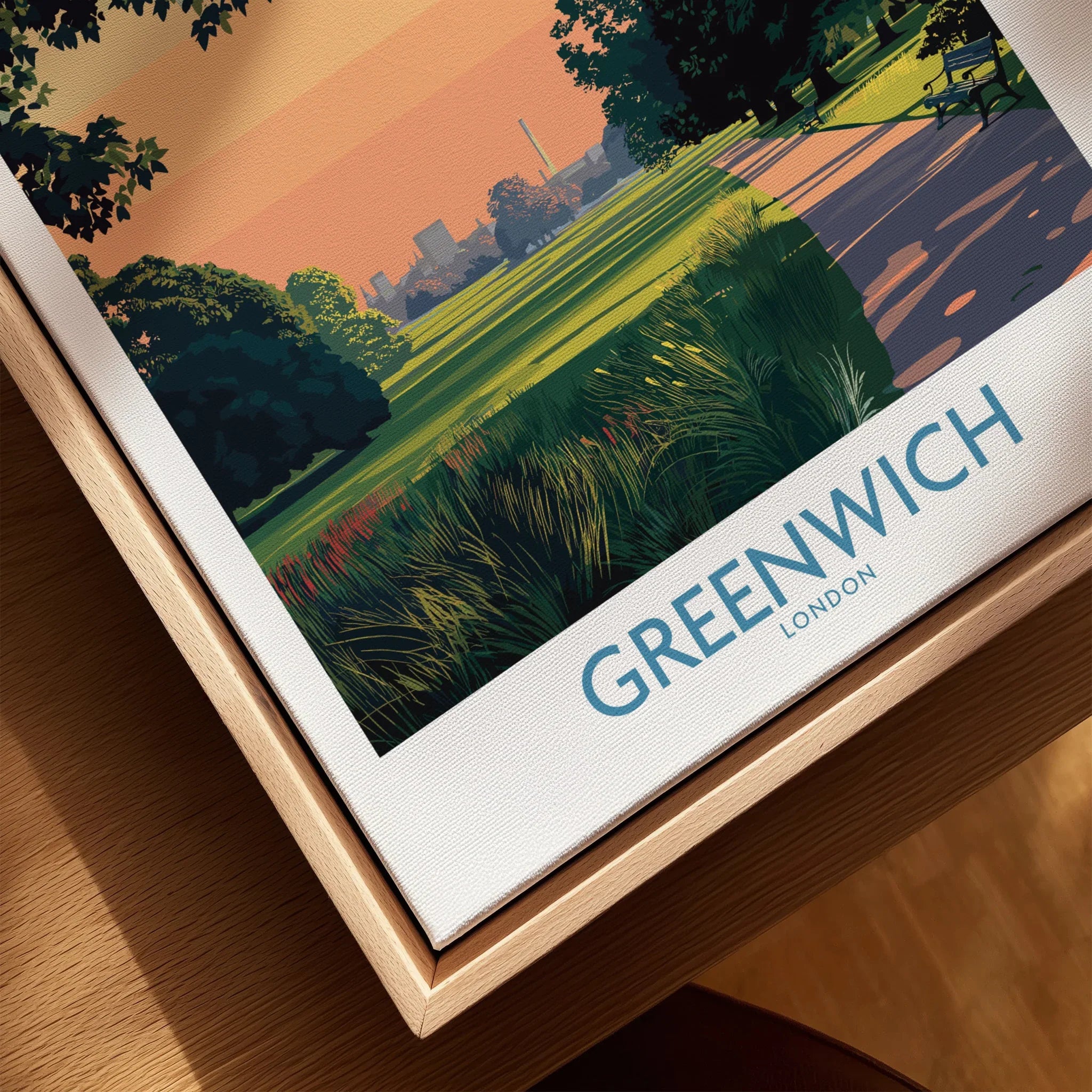 Close-up of a framed Greenwich London travel poster in natural wood floating frame