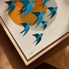 Close-up of framed canvas wall art with stylized blue birds and orange sun