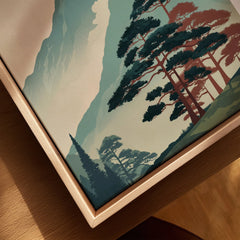 Close-up of framed canvas wall art with nature landscape and pine trees in natural wood frame