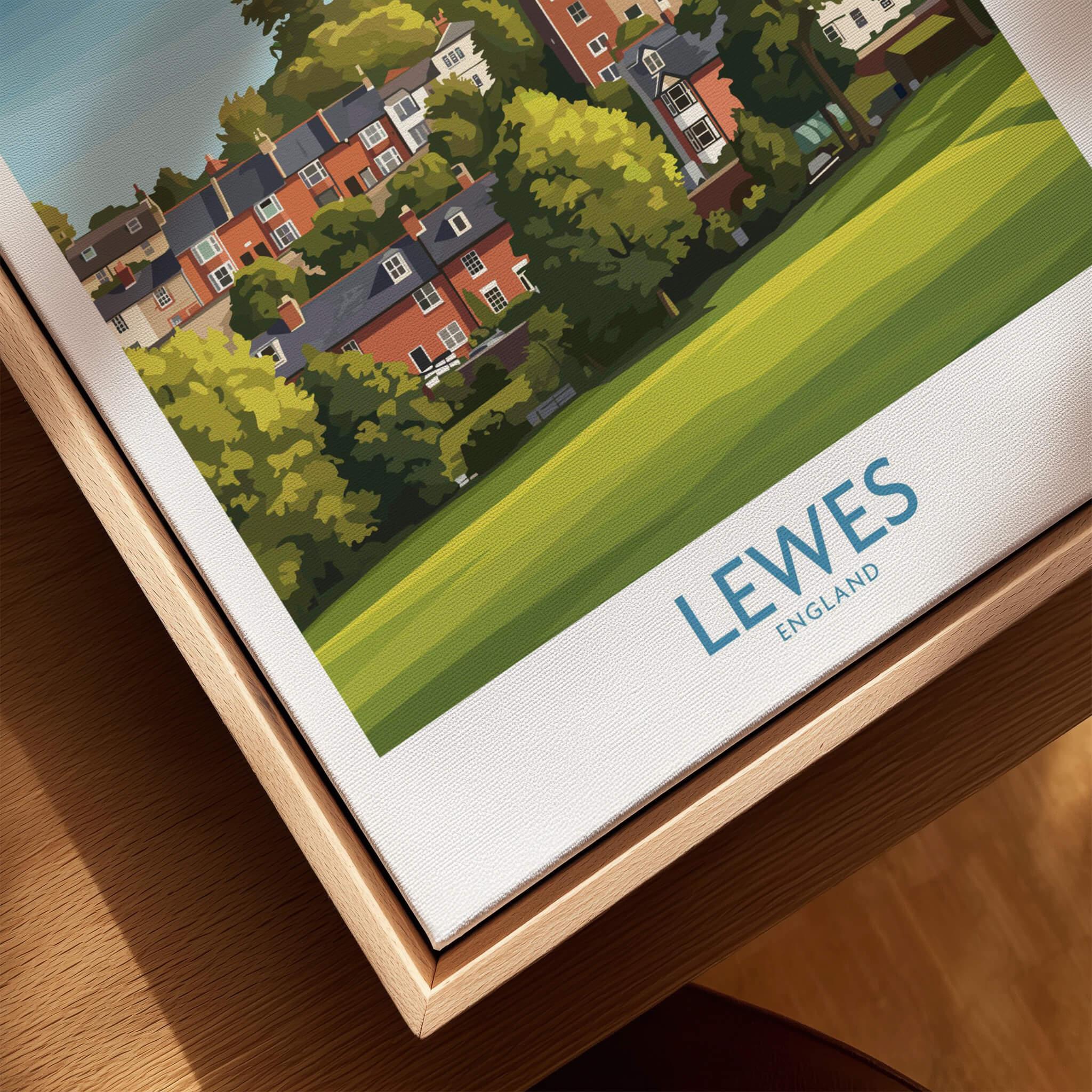 Framed Lewes England travel poster closeup, showing colorful town illustration and natural wood frame.