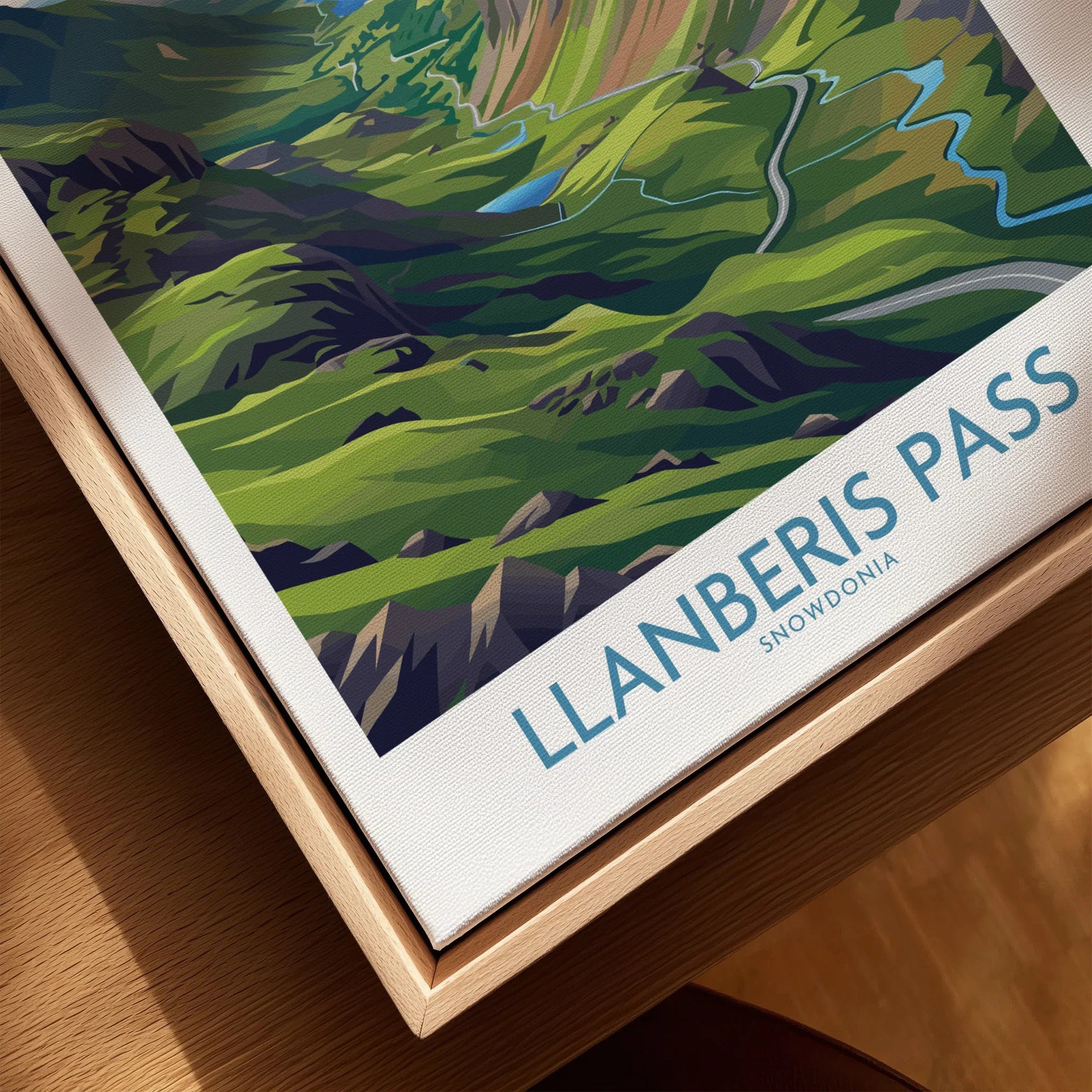 Close-up of framed Llanberis Pass Snowdonia travel poster on canvas with natural wood frame