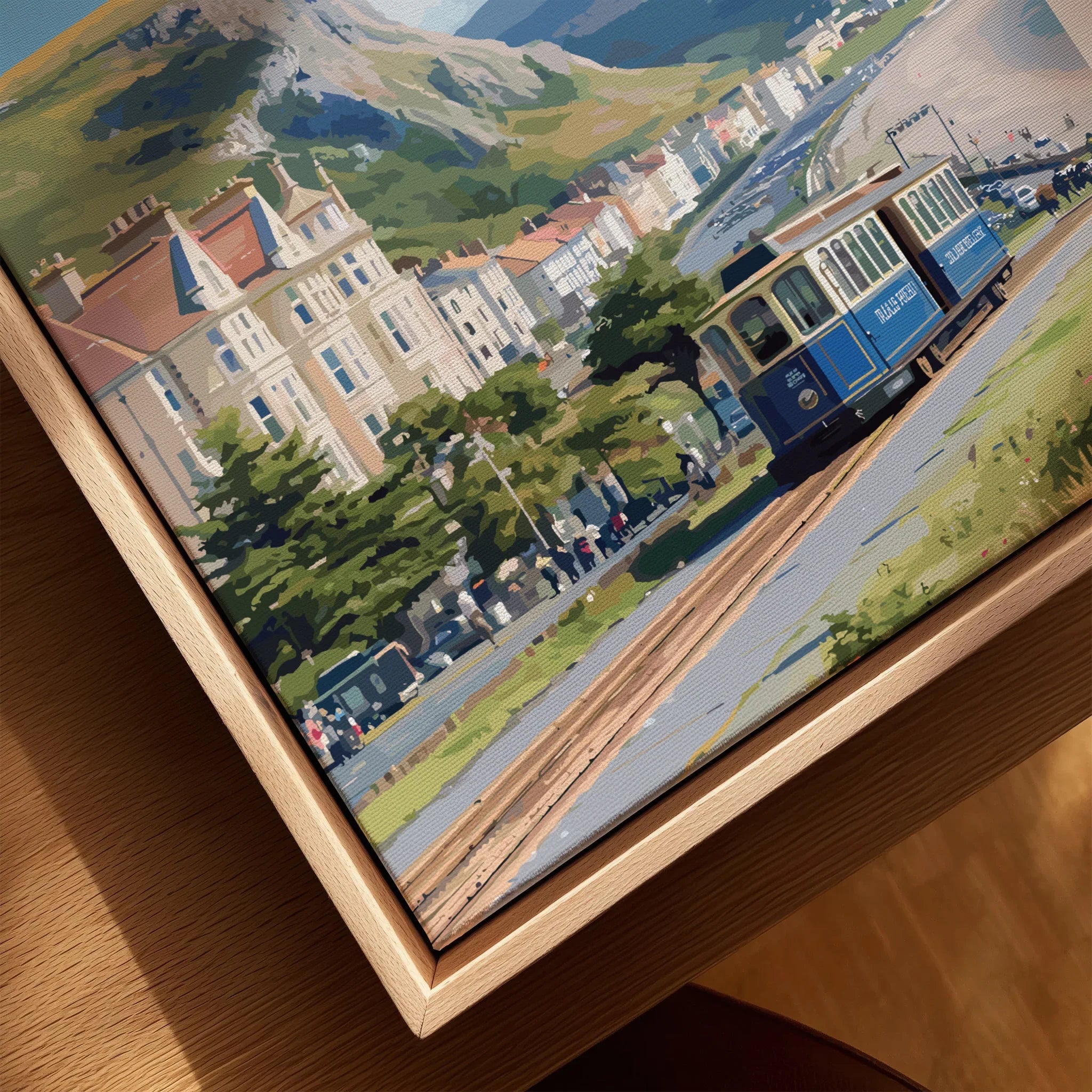 Closeup of framed canvas wall art showing a vintage tram and seaside townscape in natural wood floating frame.