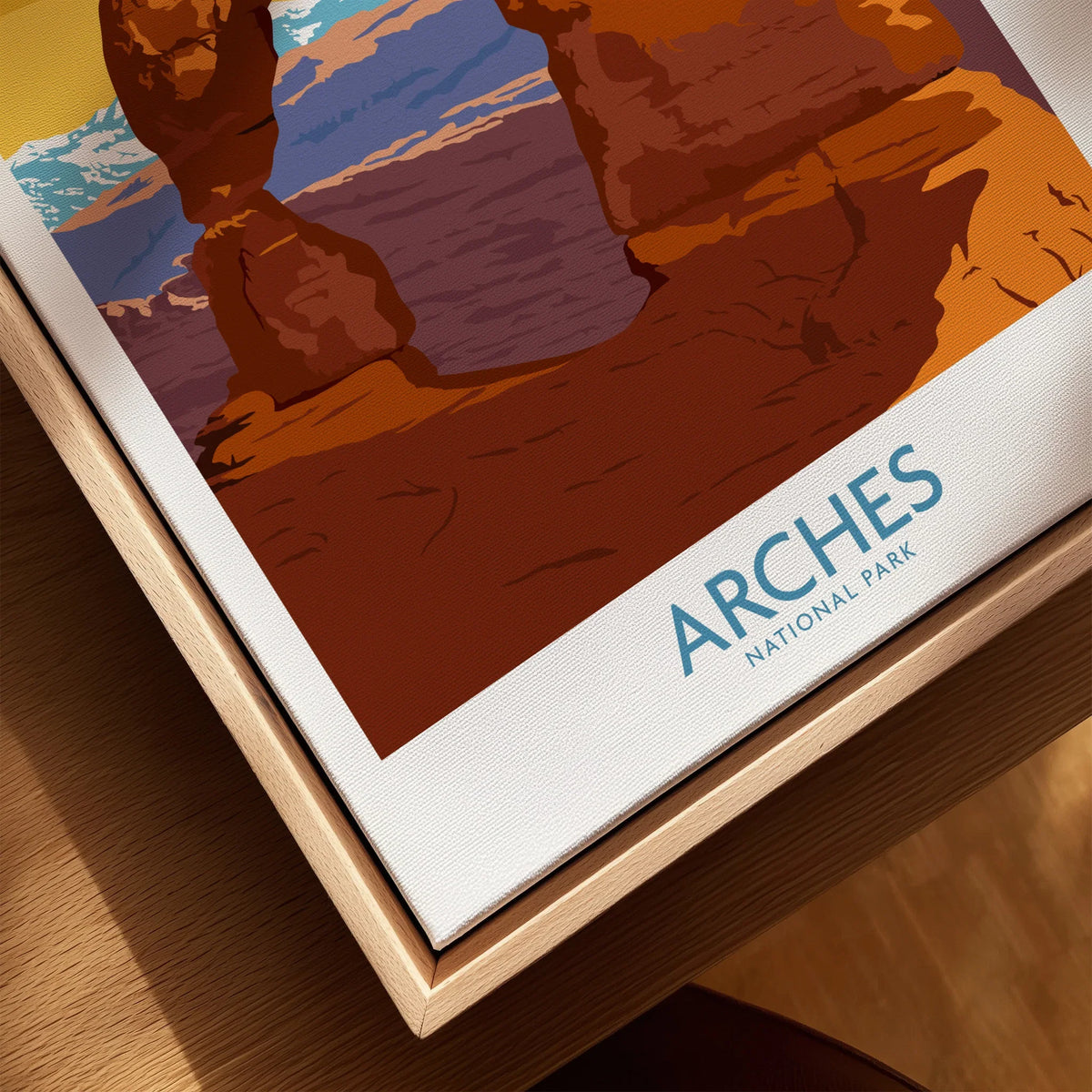 Closeup of Arches National Park travel poster on canvas in natural wood floating frame.