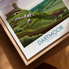Closeup of Dartmoor National Park wall art in natural wood floating frame, featuring a green landscape illustration.