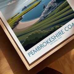 Closeup of Pembrokeshire Coast National Park travel poster in natural wood floating frame