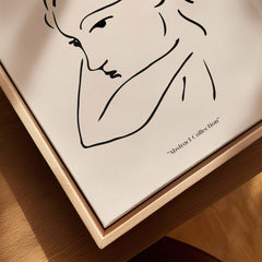 Matisse Art Prints - Abstract Line Drawing of Lady displayed in a wooden frame against a beige background.