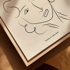 Matisse Art Prints -  Line Art Ladies Face with Wavy Hair Minimalist Poster displayed on a wooden surface with abstract design.