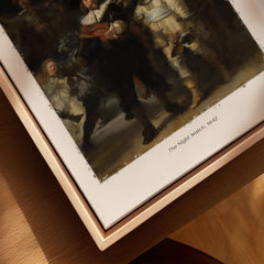 Rembrandt The Night Watch 1642 Famous Dutch Master Painting Art Print Poster displayed on wooden surface.
