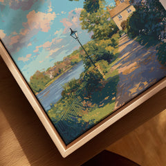 Closeup of a framed canvas wall art featuring a scenic river, trees, and sunlit path.