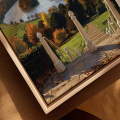 Closeup of framed canvas wall art with autumn landscape and stone staircase in natural wood frame