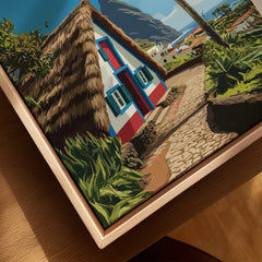 Closeup of framed canvas art featuring a colorful cottage and cobblestone path in nature.
