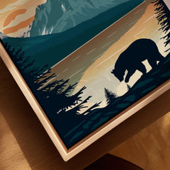 Closeup of framed canvas wall art featuring a bear silhouette by a lake at sunset with trees