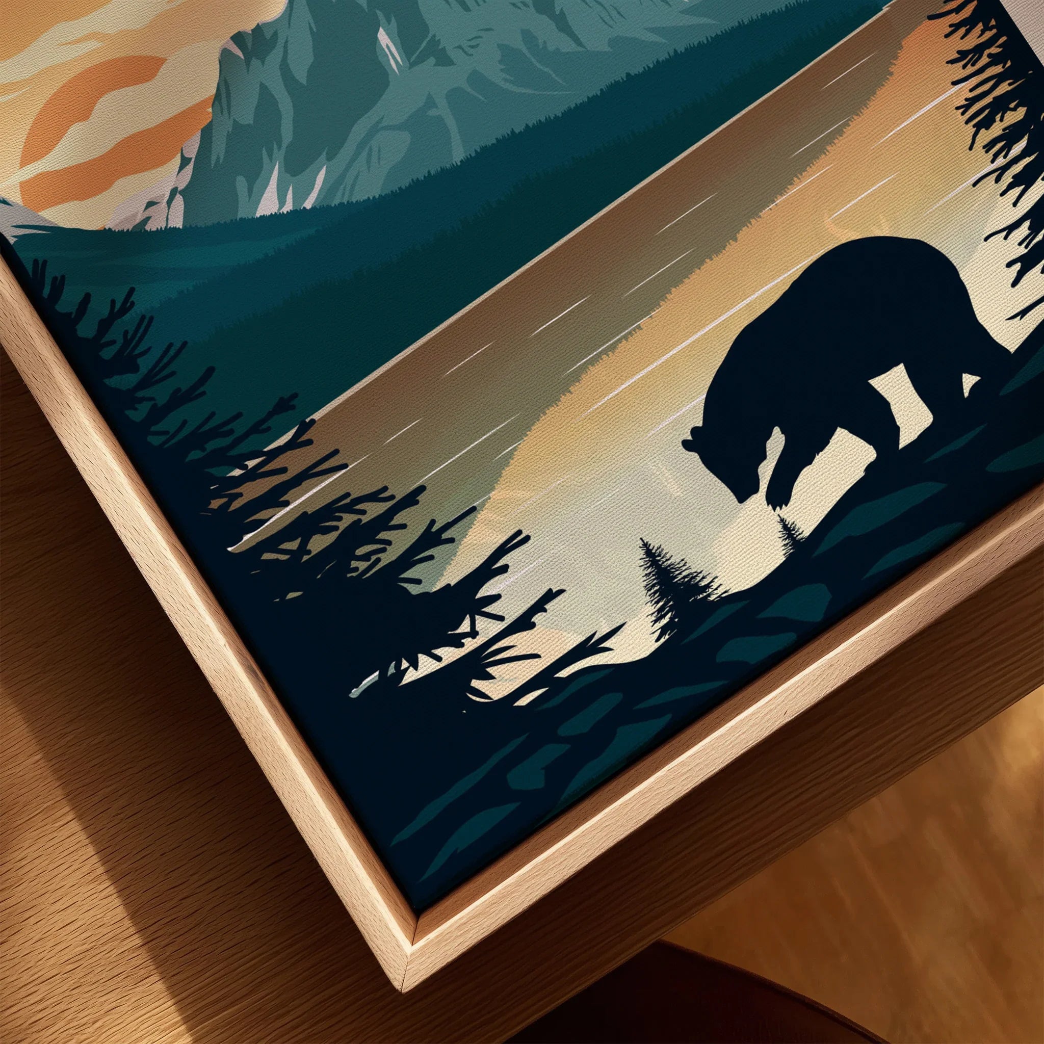 Closeup of framed canvas wall art featuring a bear silhouette by a lake at sunset with trees