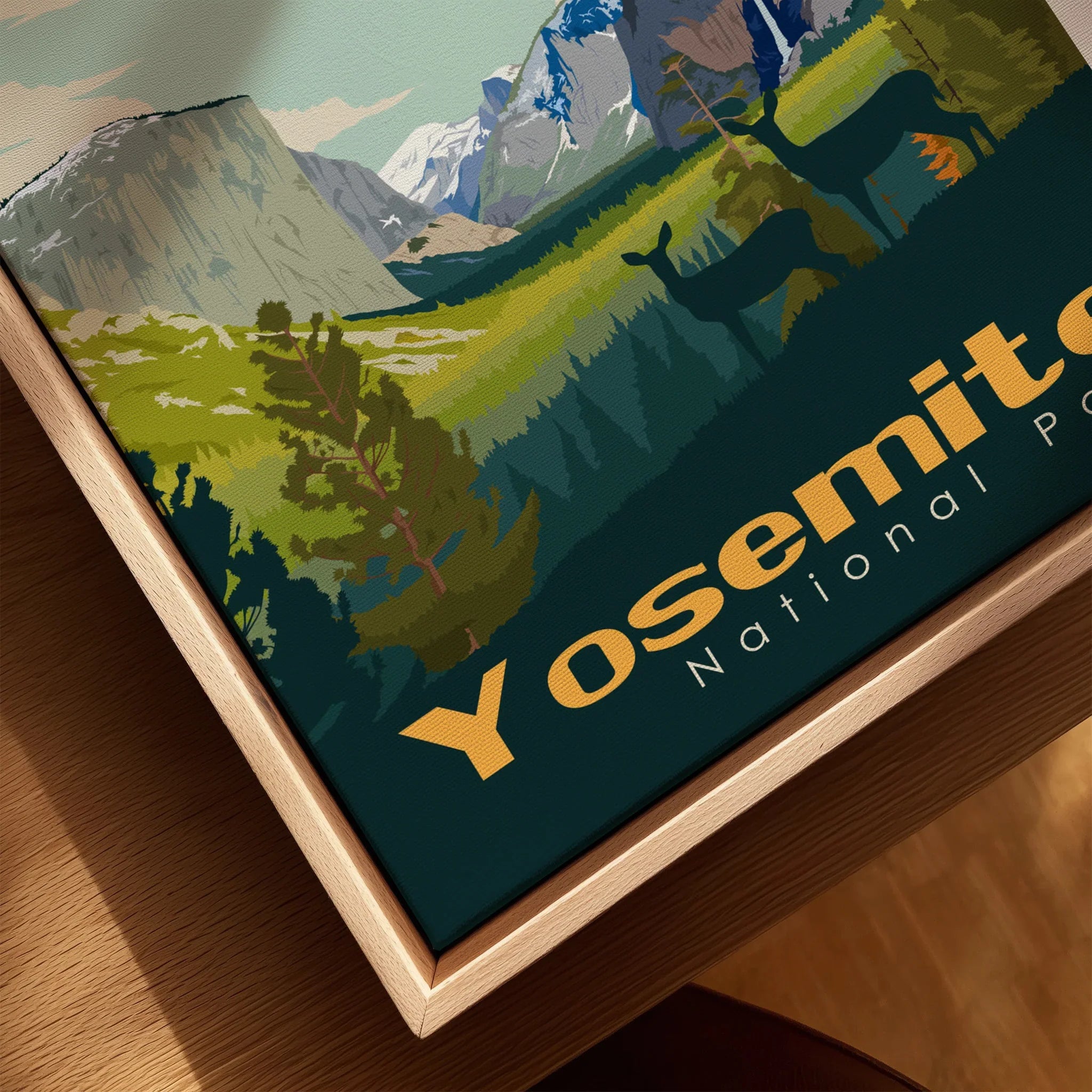 Closeup of Yosemite National Park art print in natural wood floating frame, featuring mountains, deer, and forest landscape.